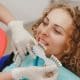 dentist-comparing-patient-s-teeth-shade-with-samples-bleaching-treatment